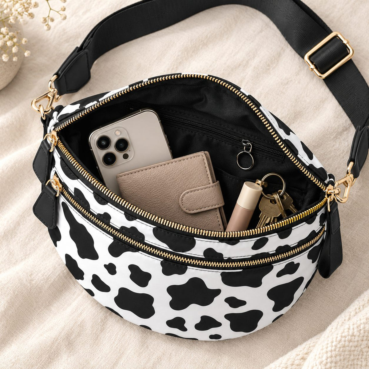 Open ZOCOIFY Everyday Roomy Crossbody Bag in cow print showing phone, wallet, keys and lip balm inside