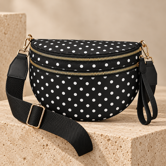 ZOCOIFY Everyday Roomy Crossbody Bag in black with white polka dots on a warm stone pedestal